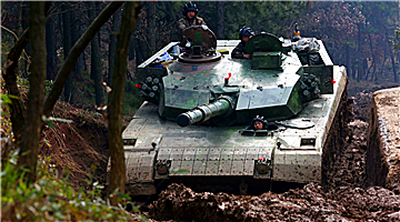Type-96 main battle tanks cross muddy trench
