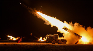 Female soldiers fire rockets at night in desert