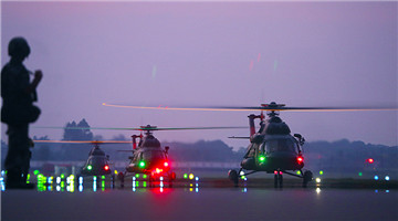 Transport helicopters ready to lift off at night