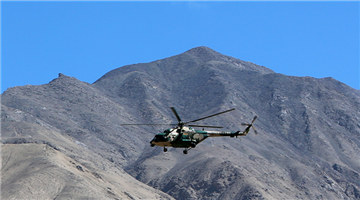 Transport helicopter flies over mountains