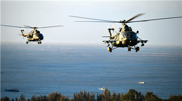 Helicopters hover above sea