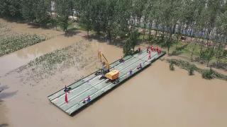 Powered pontoon bridge deployed to help seal breached dike